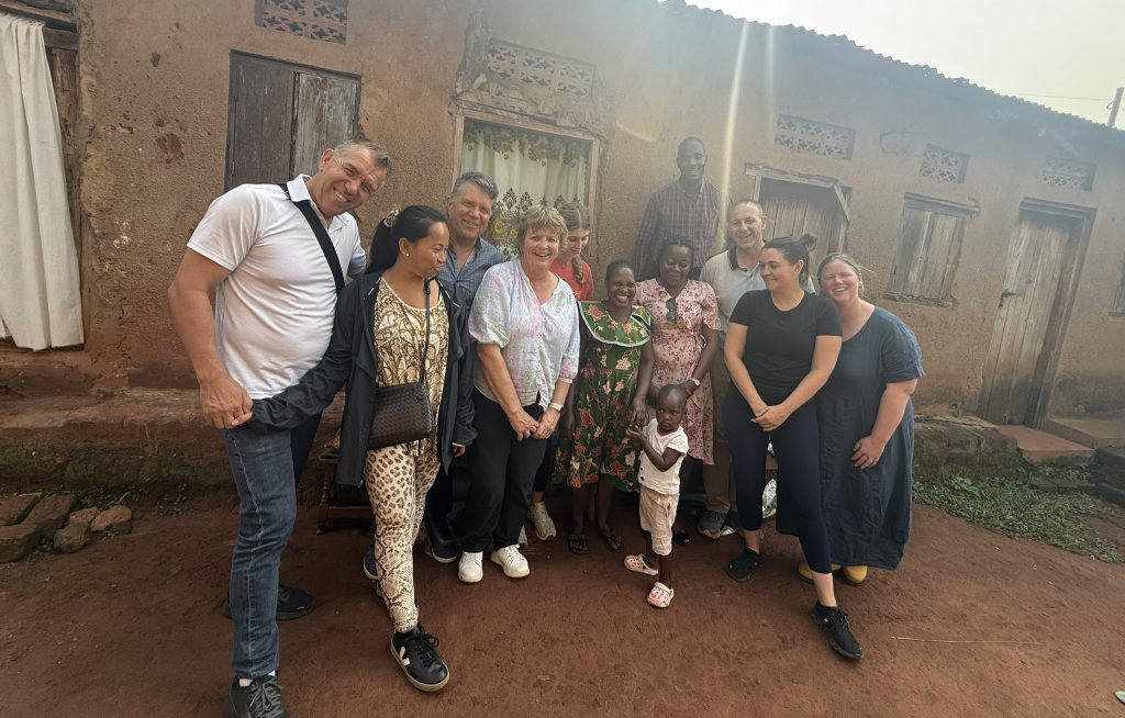 Group on Immersion trip standing in front of local house with local family